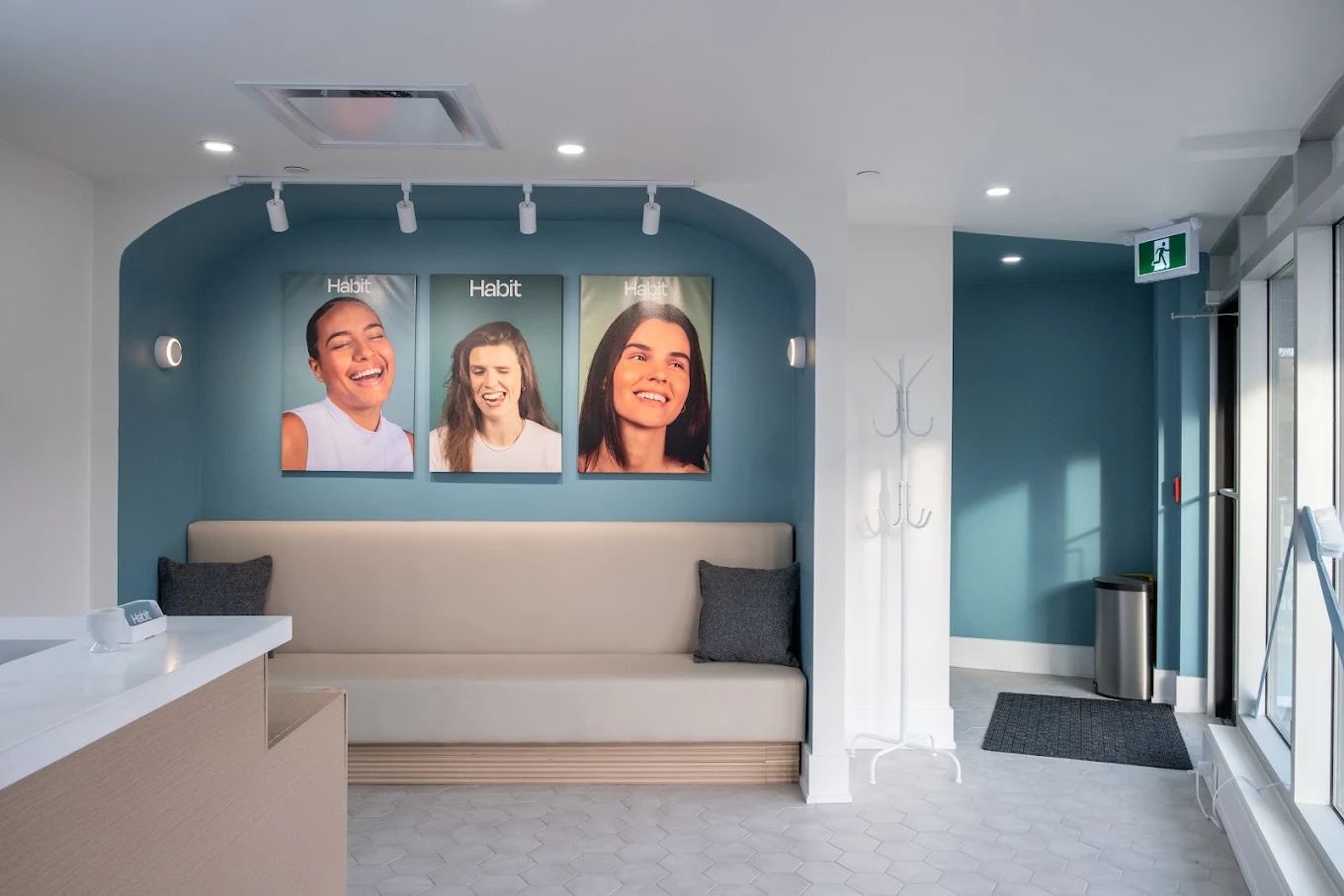 Habit Dental waiting lounge with teal walls and Habit smile posters
